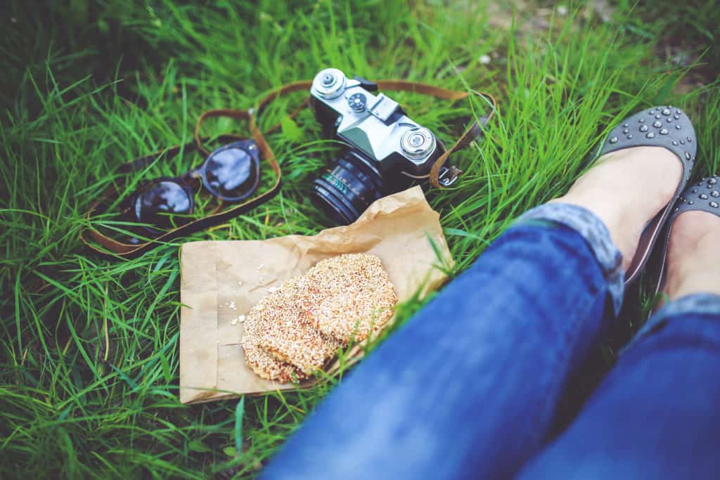 woman sitting in grass with camera