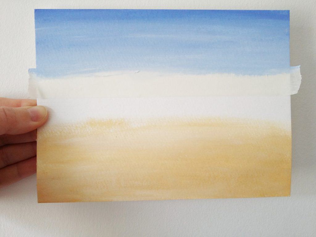 This tutorial for a quick and deceptively simple beach scene painting is a great creative project for the summer. Click through for the steps to paint your own beach!