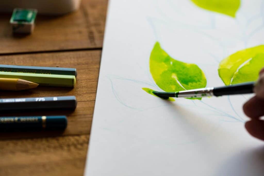 close up of person painting watercolour leaves